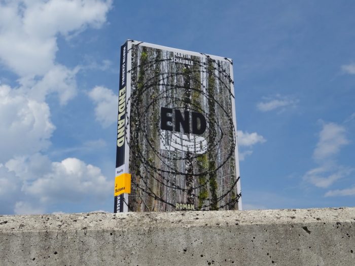 Das Buch "Endland" steht auf einer Betonmauer.